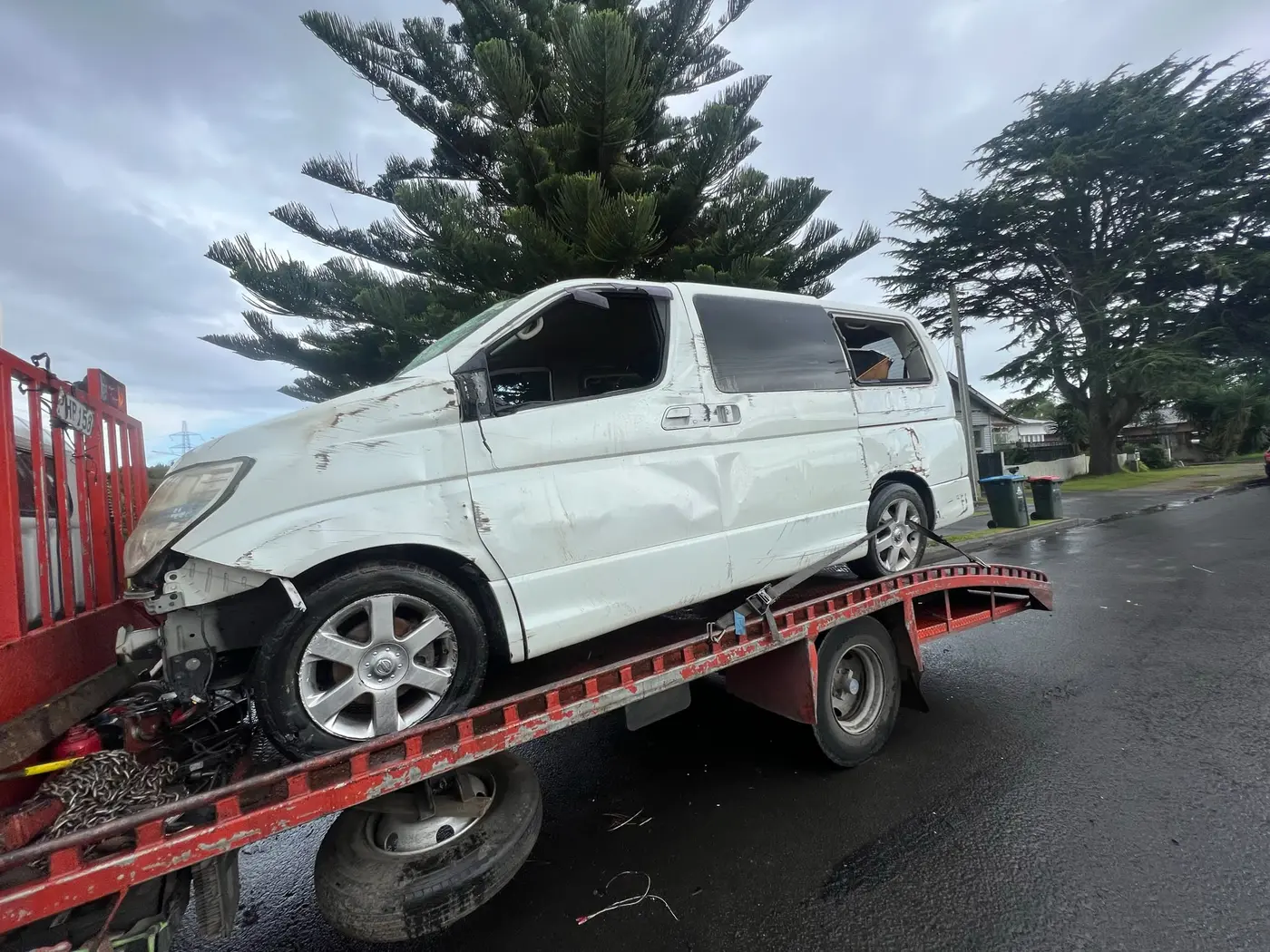 Crashed white van on a tow truck deck