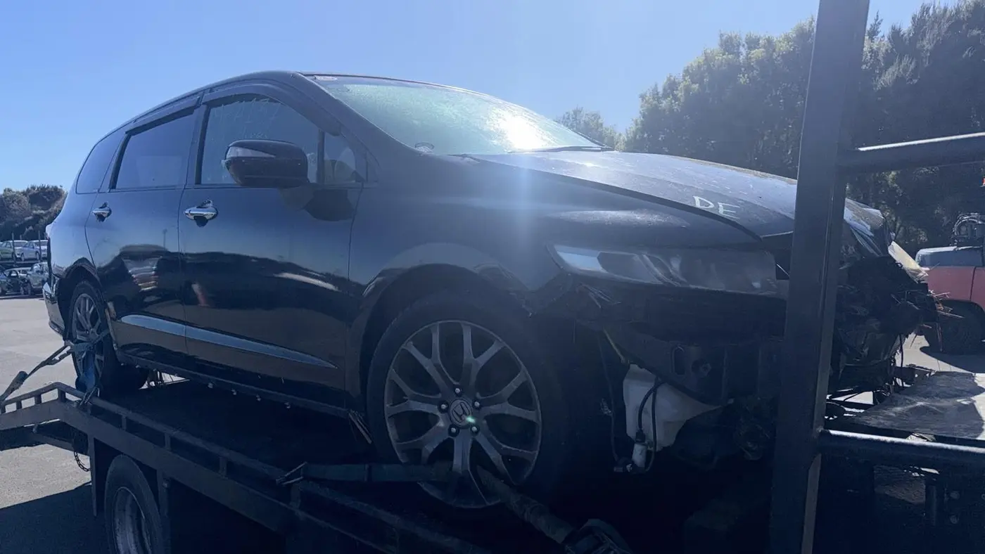 Dark hatchback on a tow truck