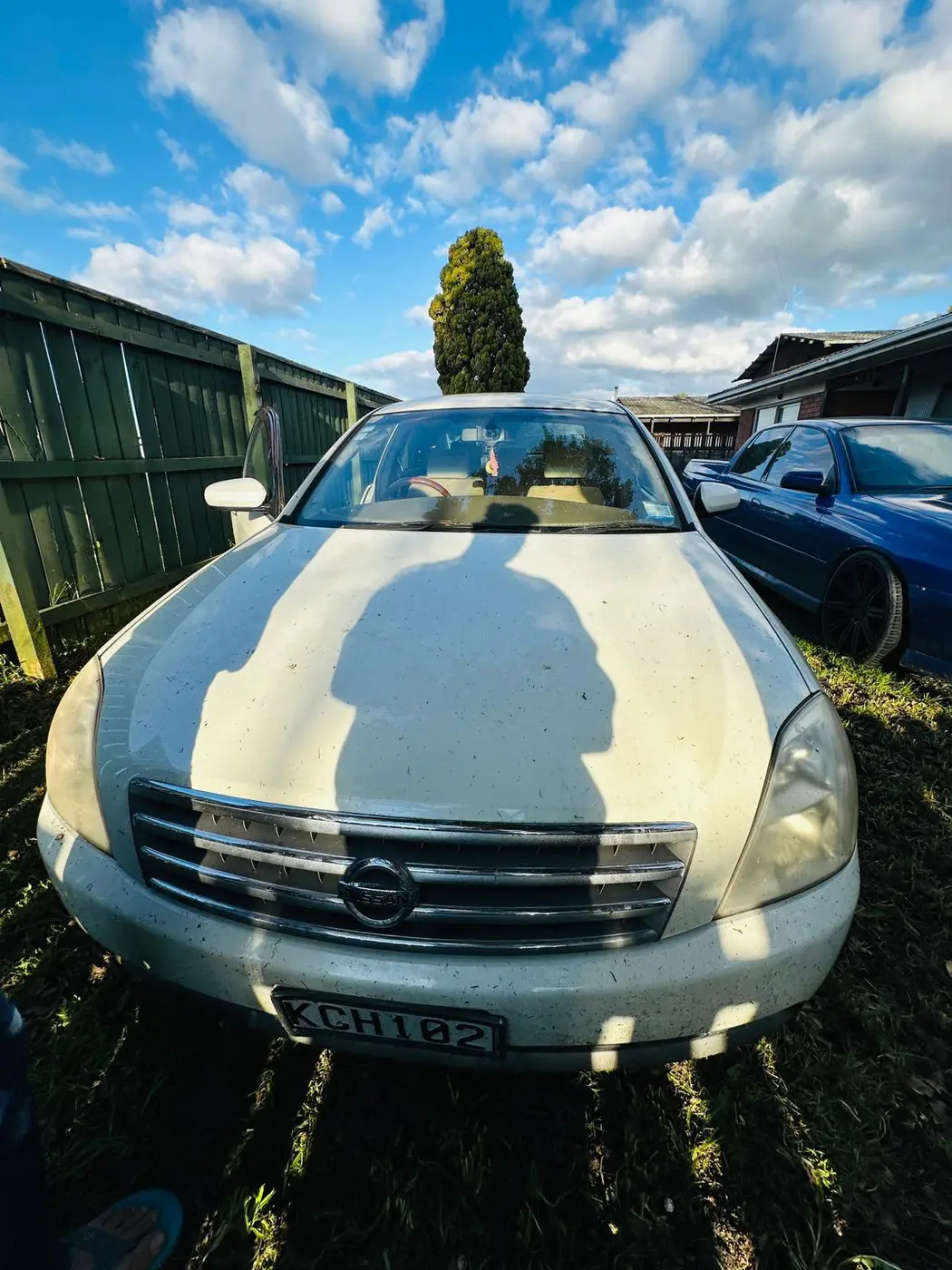 Old Nissan sedan with faded, weathered paint