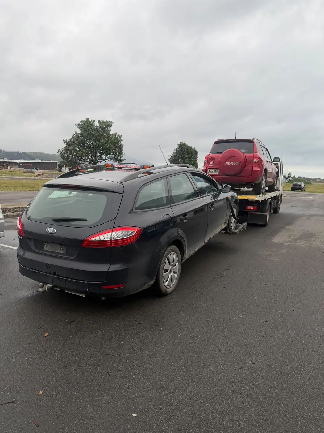 Ford wagon waiting to be collected beside a tow truck