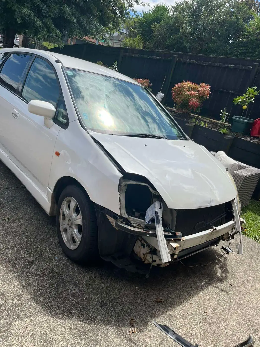 White hatchback with front-end damage